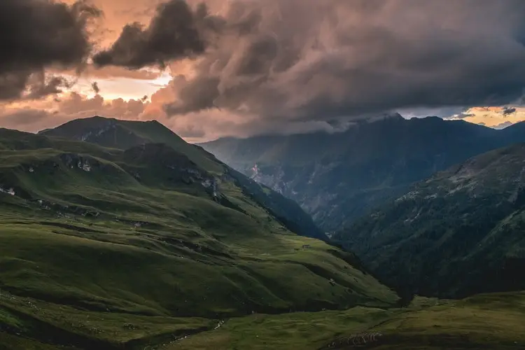 green mountain range with pink clouds