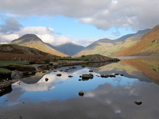 reflection of clouds and mountains on stream