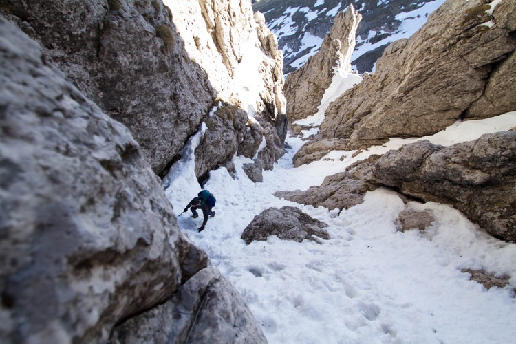 Rock climber in snowy mountain range