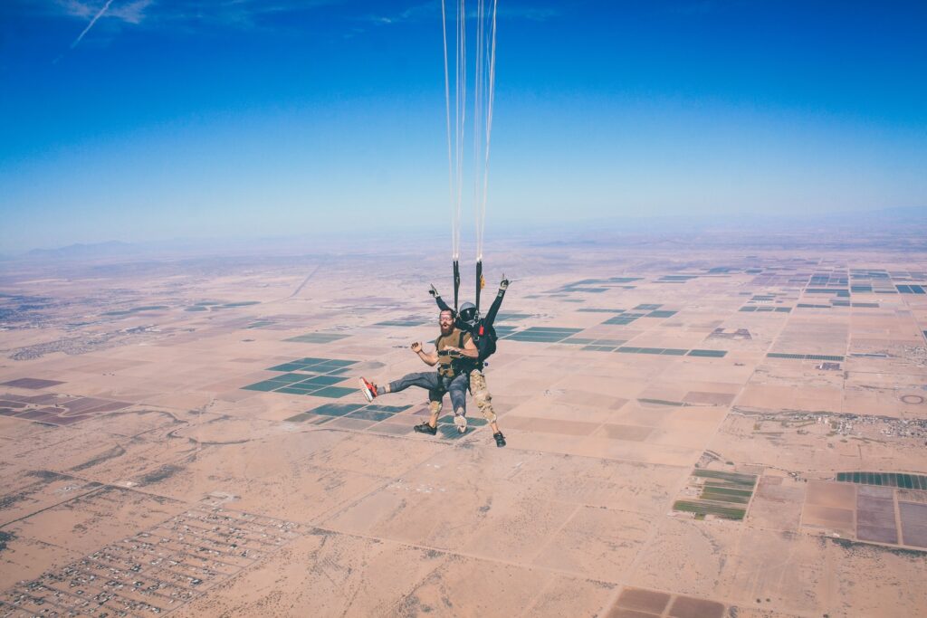 two sky divers with open parachute