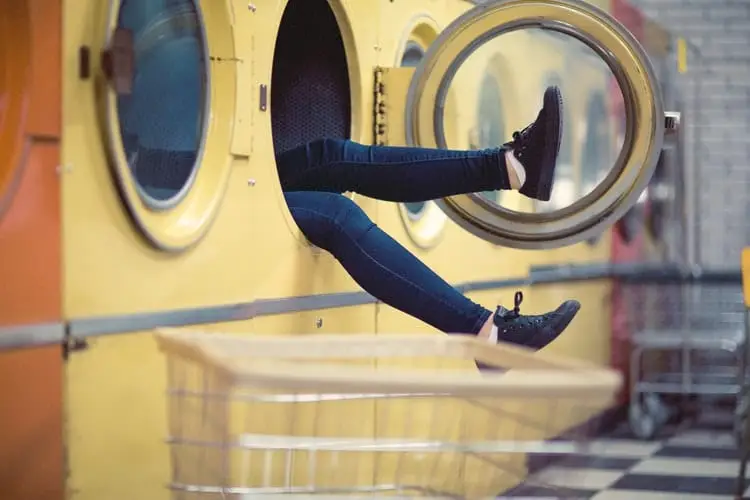 two feet and legs sticking out of washing machine