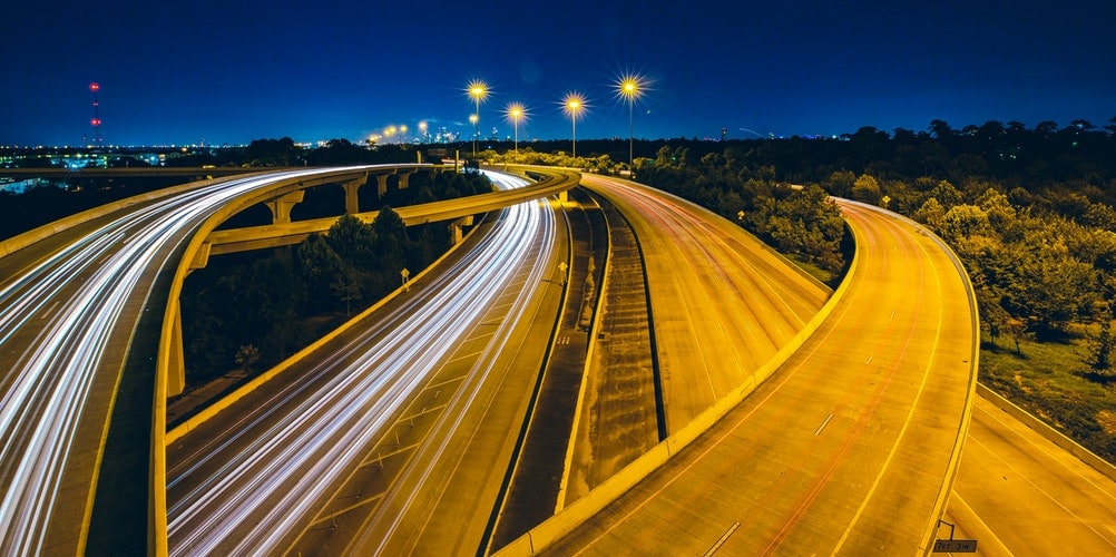 empty highway with view of city and trees