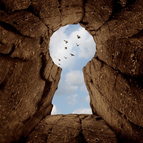 rock formation with birds flying above